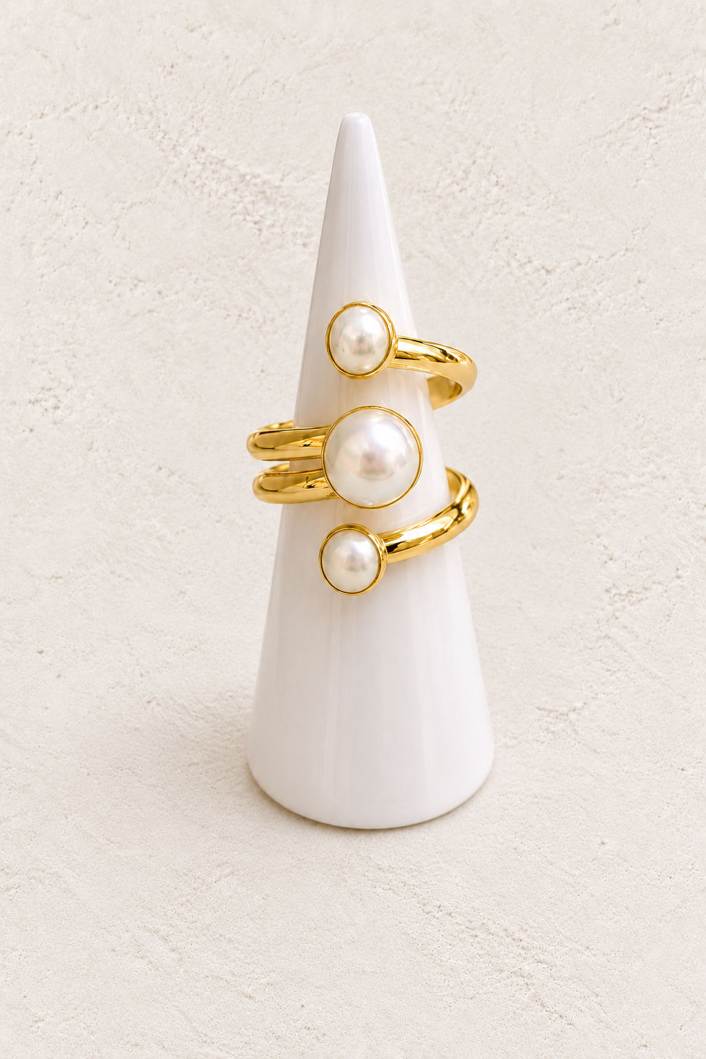 Meliora Freshwater Pearl Ring (Adjustable) on white cone against warm textured background