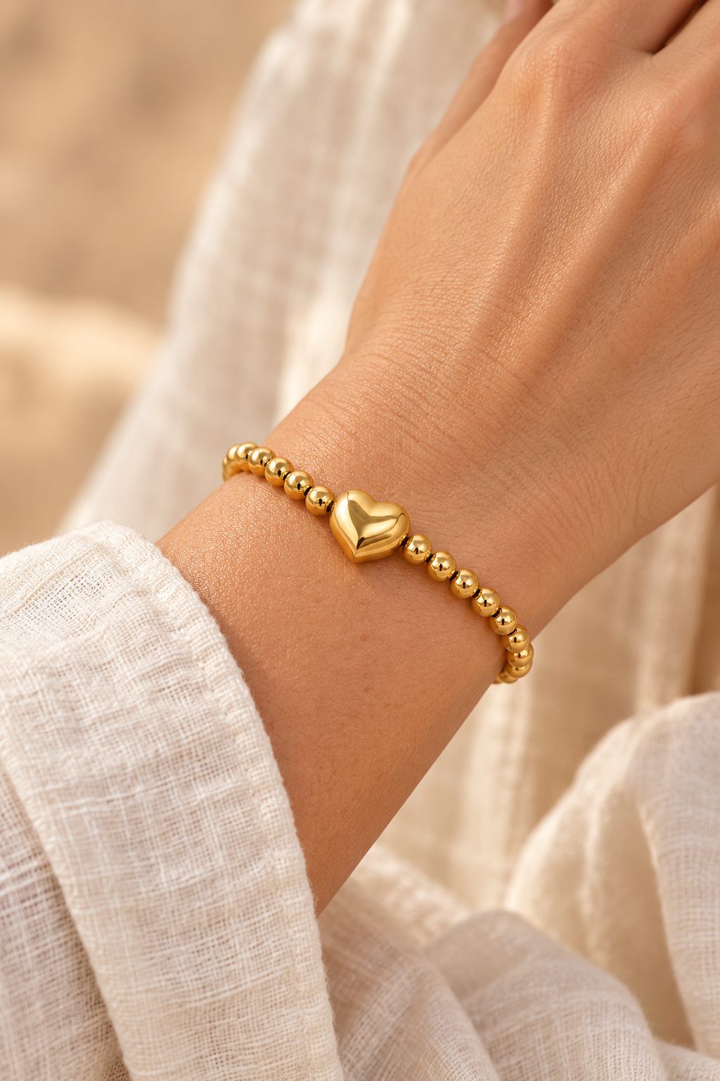
                  
                    Gold Bead Heart Bracelet worn on a model's wrist
                  
                