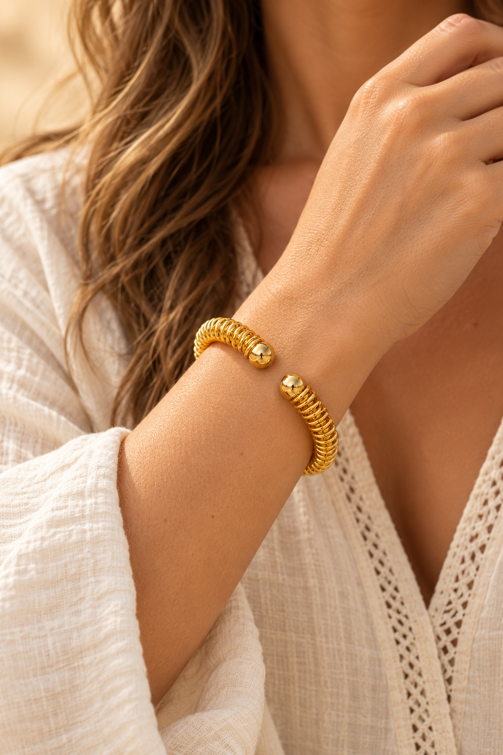 Gold Coil Open Cuff Bracelet worn on a model's wrist