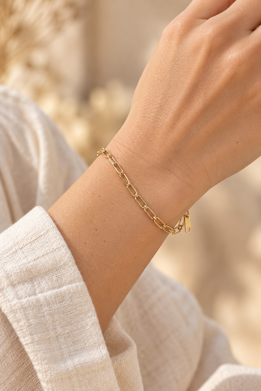 
                  
                    Gold Textured Mini Paperclip Bracelet worn on a model's wrist
                  
                