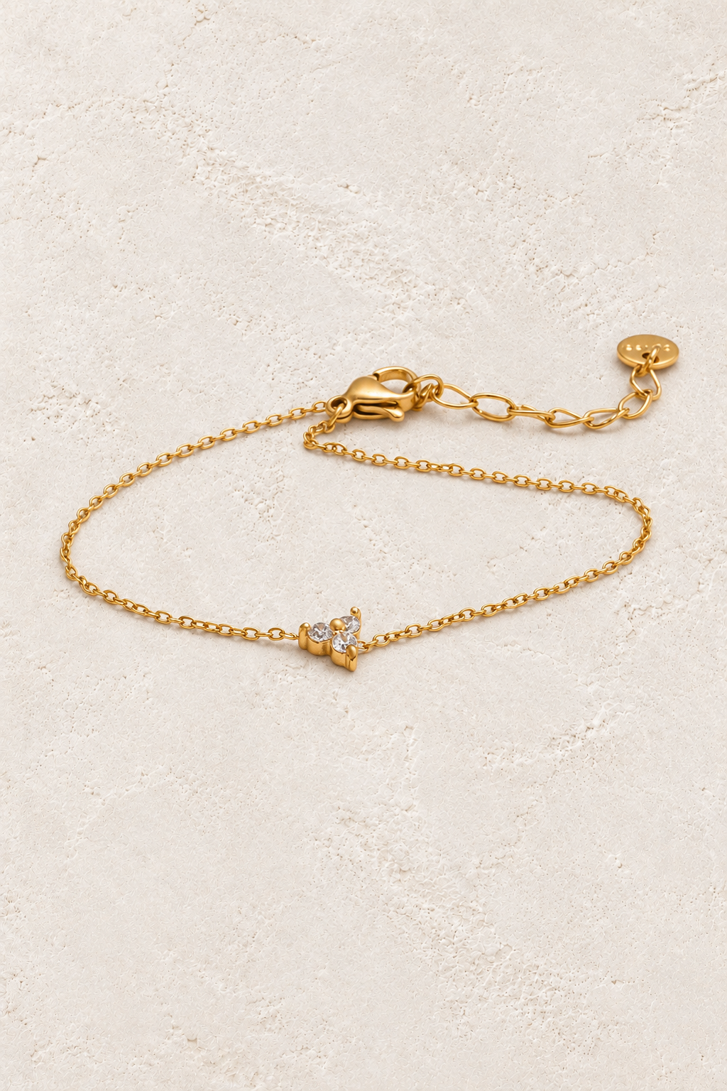 Gold crystal butterfly chain bracelet on approved ivory stone background