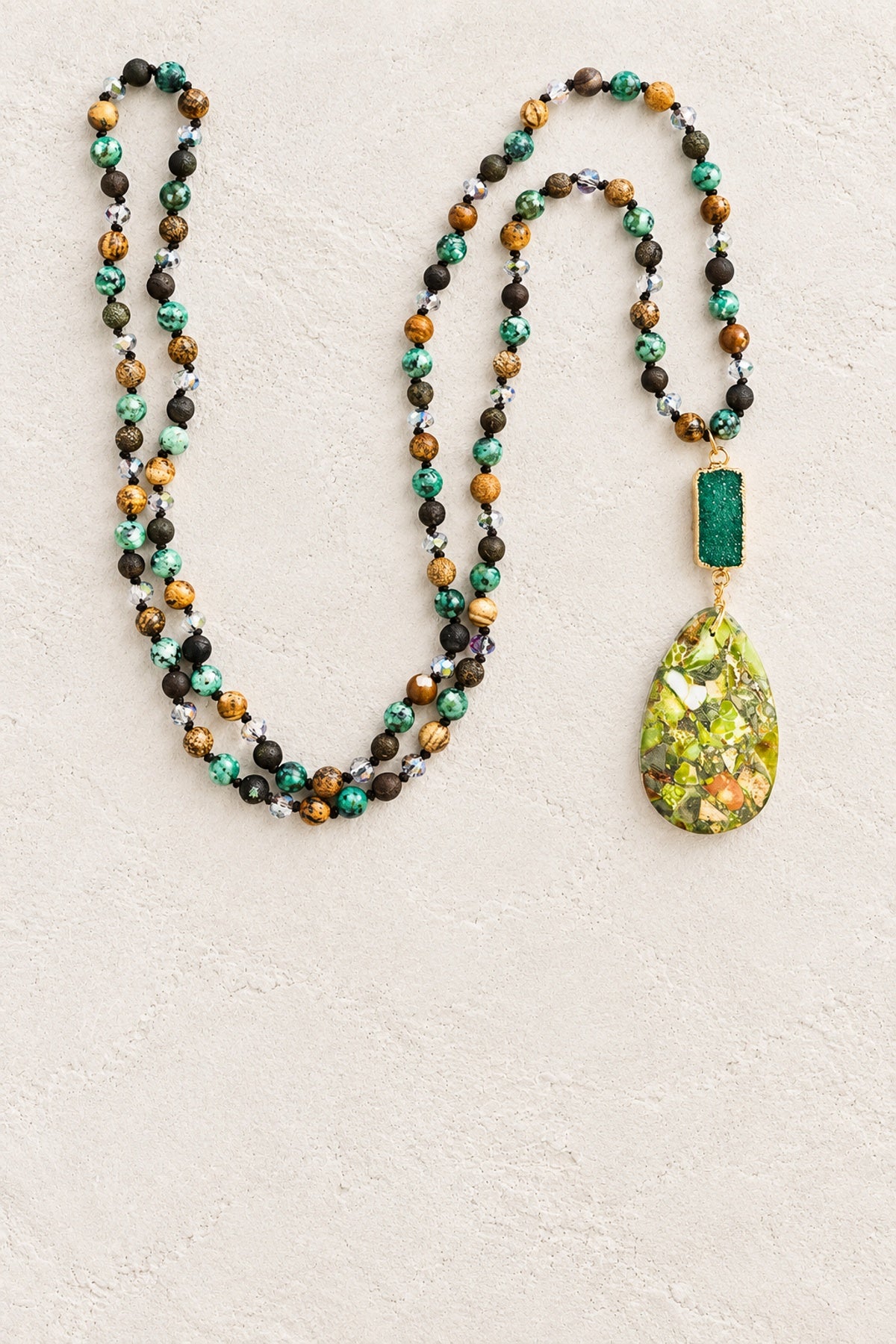 Green Mixed Agate Tribal Necklace on warm cream plaster background