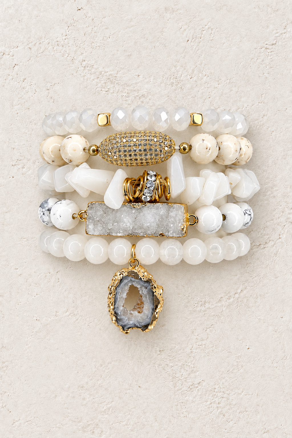 Ivory Luxe 5-piece elastic bracelet stack on warm textured background