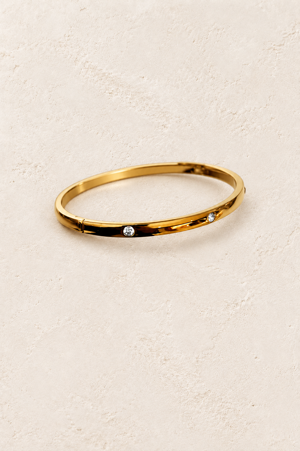 Lola Gold Stud Bangle on cream beige textured background