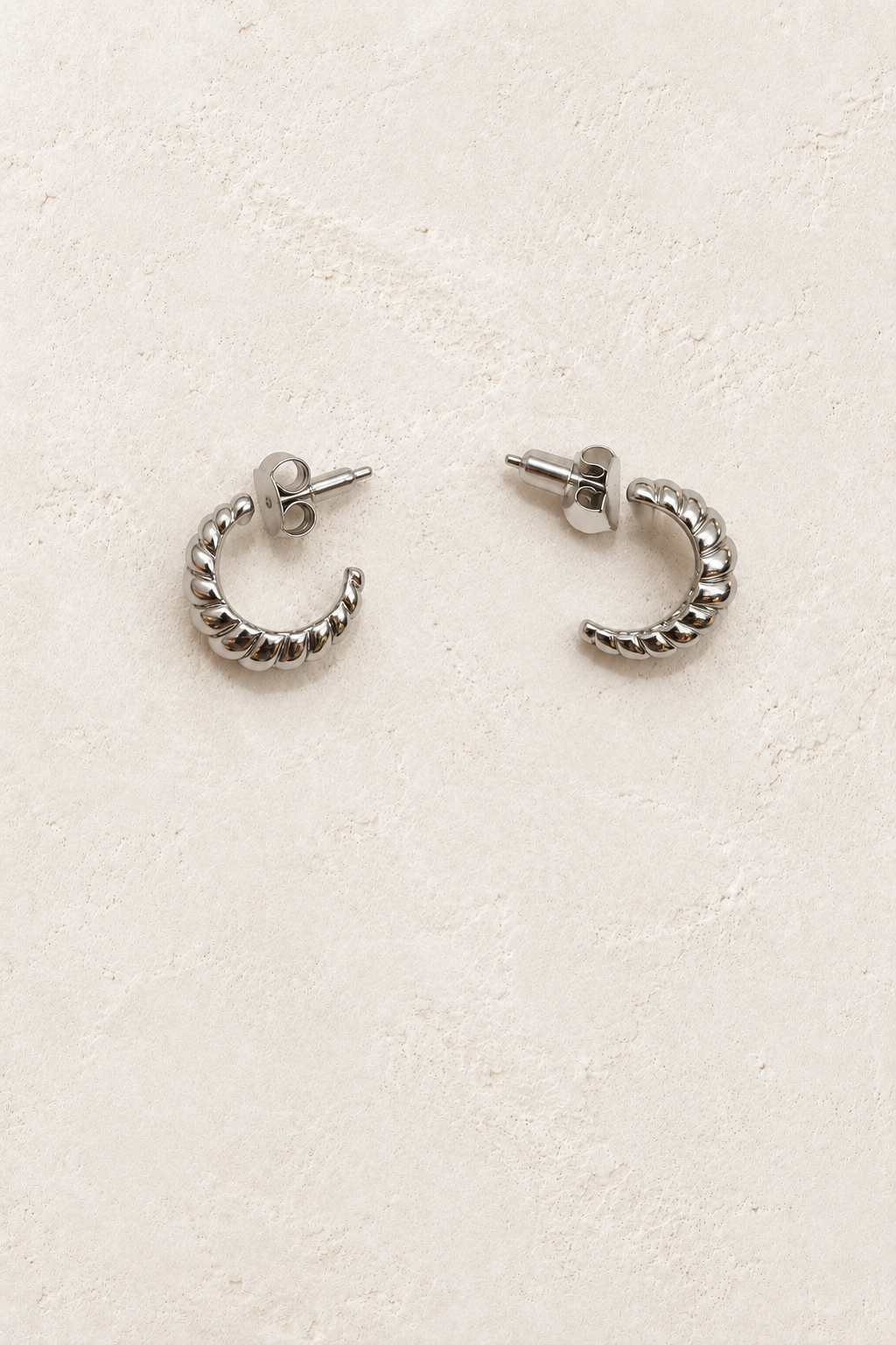 
                  
                    Lucette Silver Rope Hoop Earrings on warm ivory plaster
                  
                