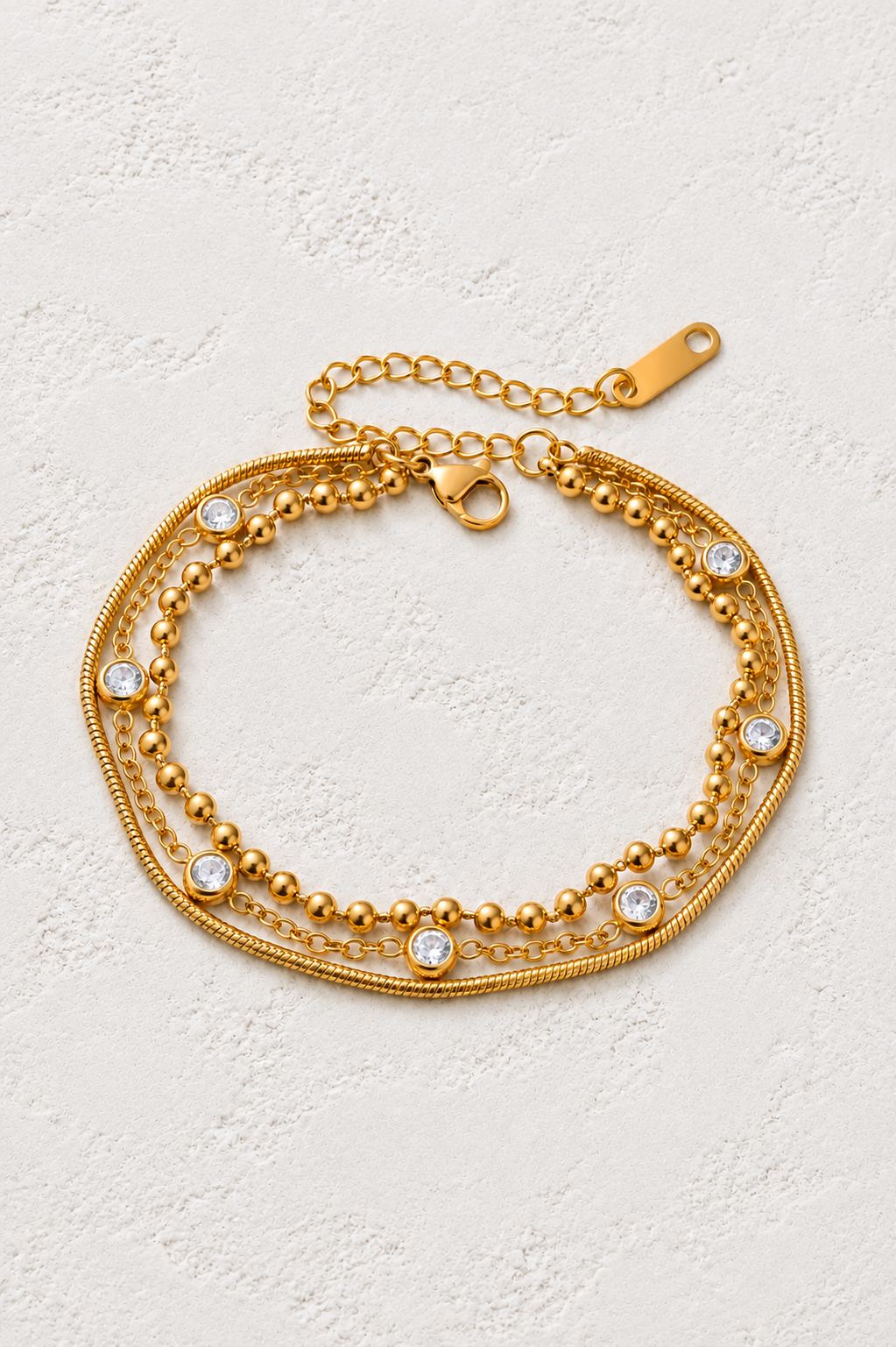 Luna Gold Crystal Layered Bracelet on neutral ivory plaster