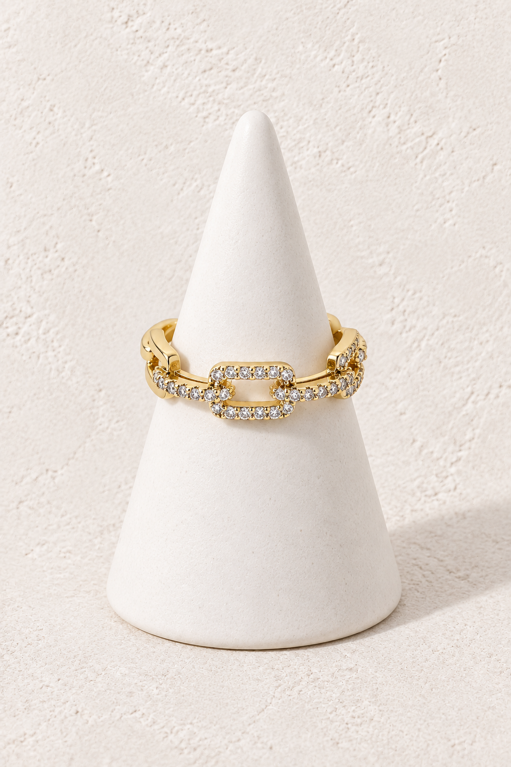 Luna Link Ring on a white display cone against a warm textured background