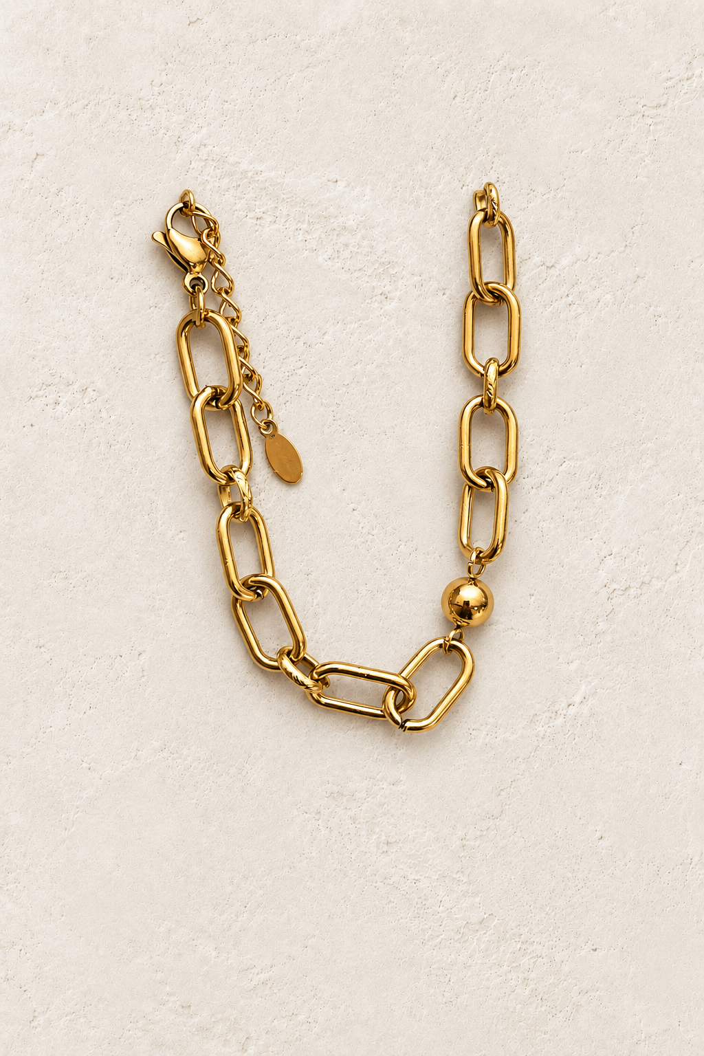 
                  
                    Maelle Gold Bead & Paperclip Bracelet on cream beige textured background
                  
                