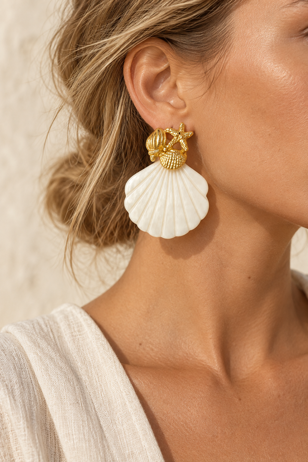 Model wearing Marea gold starfish and pearly shell earring