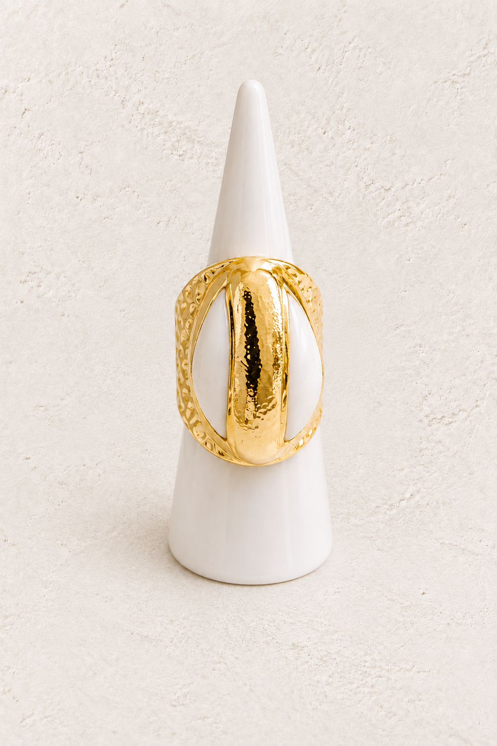 Marella Cowrie Shell Ring (Adjustable 6-9 size) on white cone against warm textured background