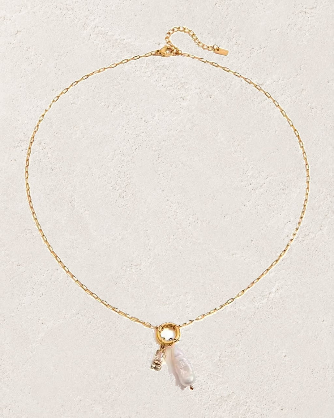
                  
                    Marina Pearl April Clear Crystal birthstone necklace on cream plaster background
                  
                