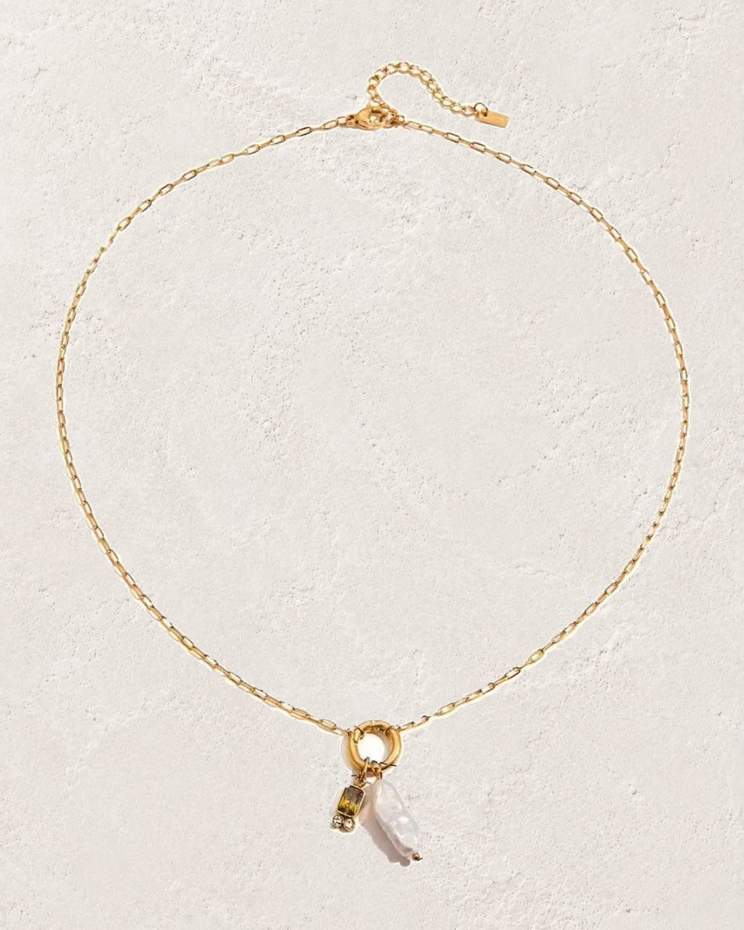 
                  
                    Marina Pearl August Peridot birthstone necklace on cream plaster background
                  
                