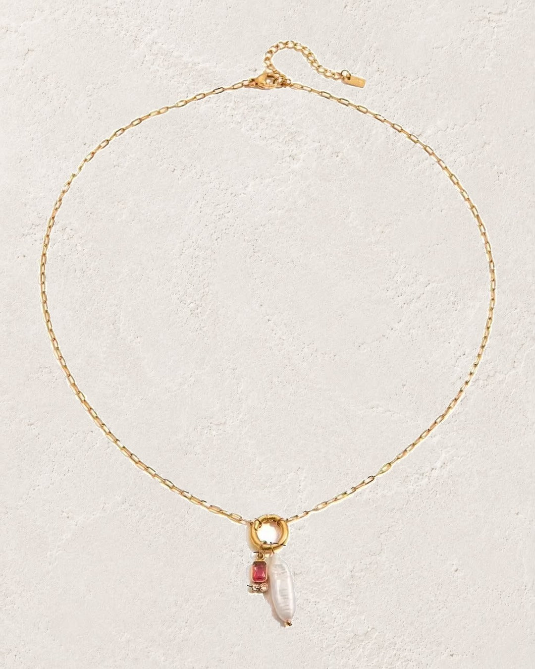 
                  
                    Marina Pearl July Ruby birthstone necklace on cream plaster background
                  
                