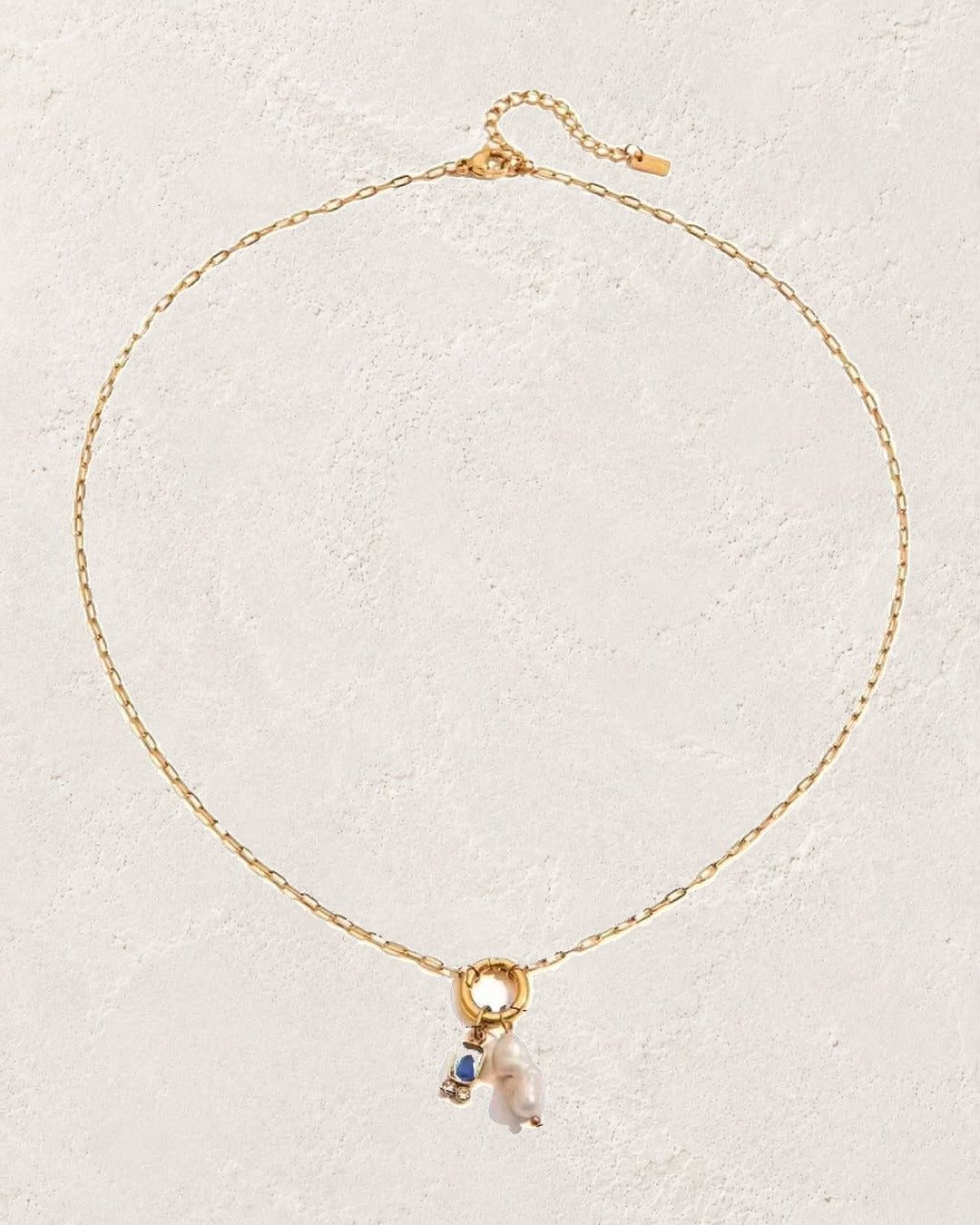 
                  
                    Marina Pearl March Aquamarine birthstone necklace on cream plaster background
                  
                