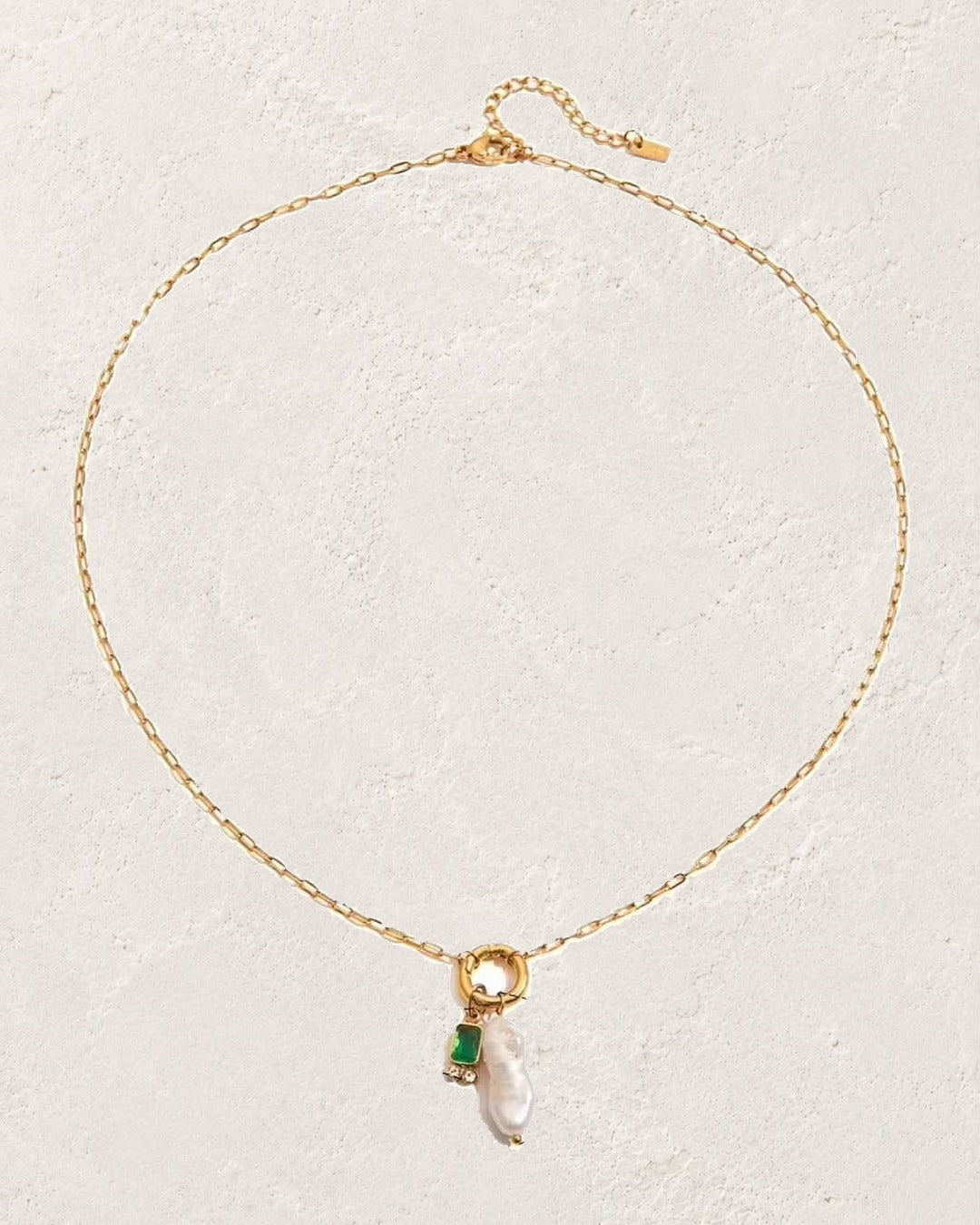
                  
                    Marina Pearl May Emerald birthstone necklace on cream plaster background
                  
                