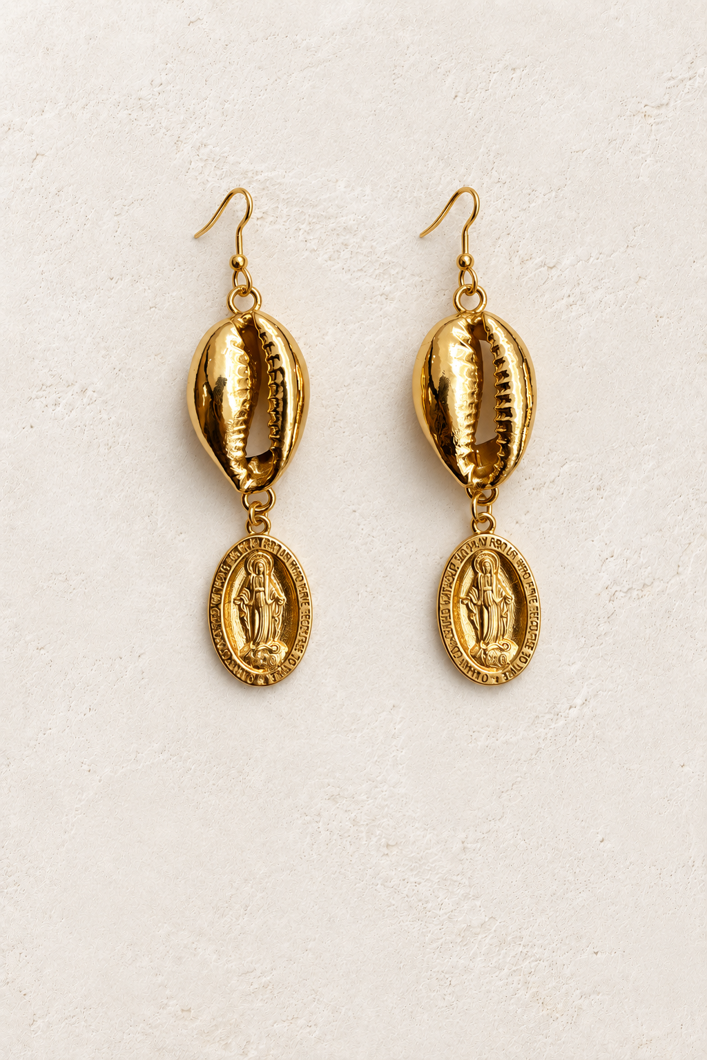 
                  
                    Maristella Gold Cowrie & Medallion Earrings on cream plaster background
                  
                