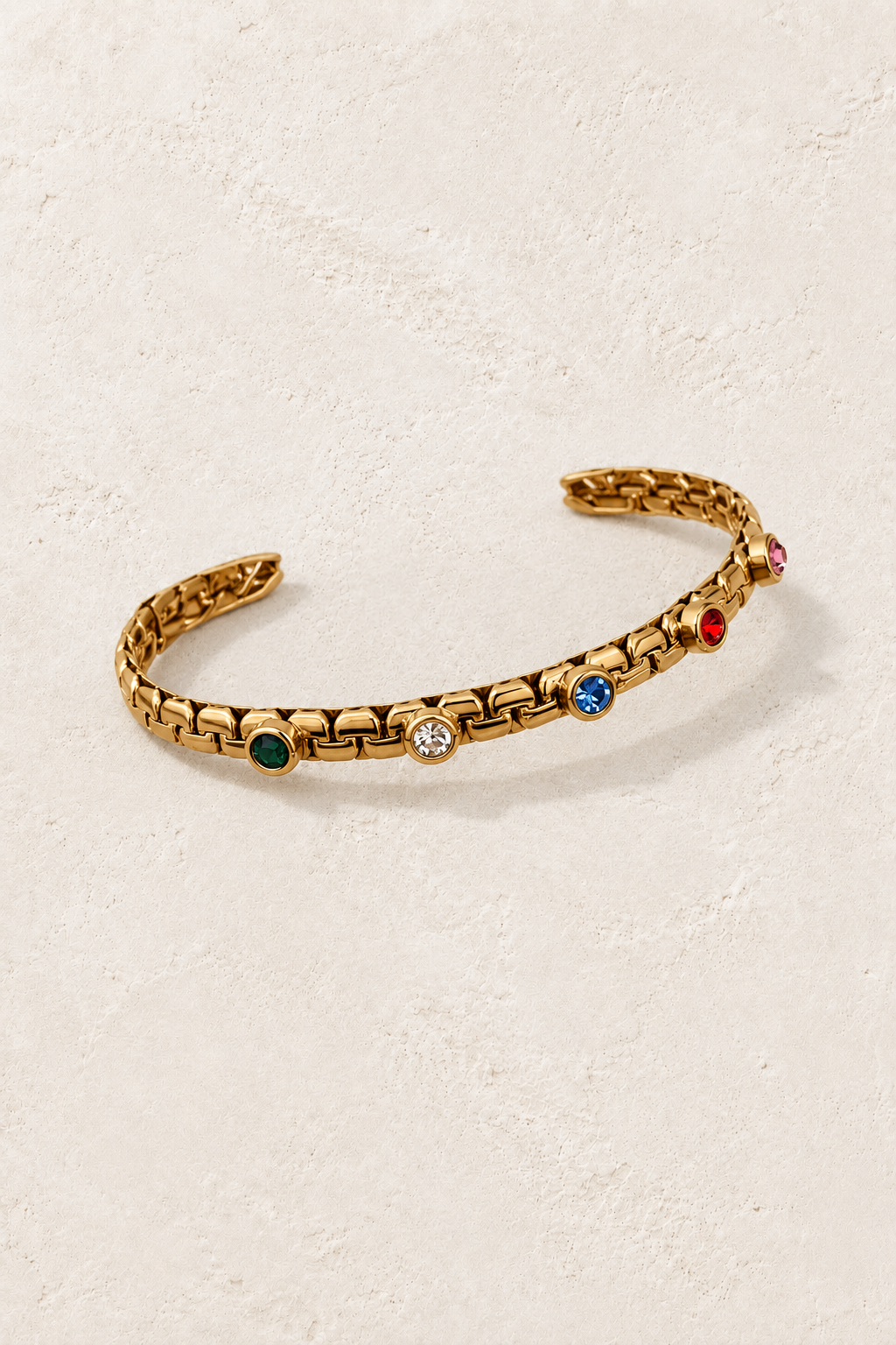 Mira Gold Multicolour Link Bangle on cream beige textured background