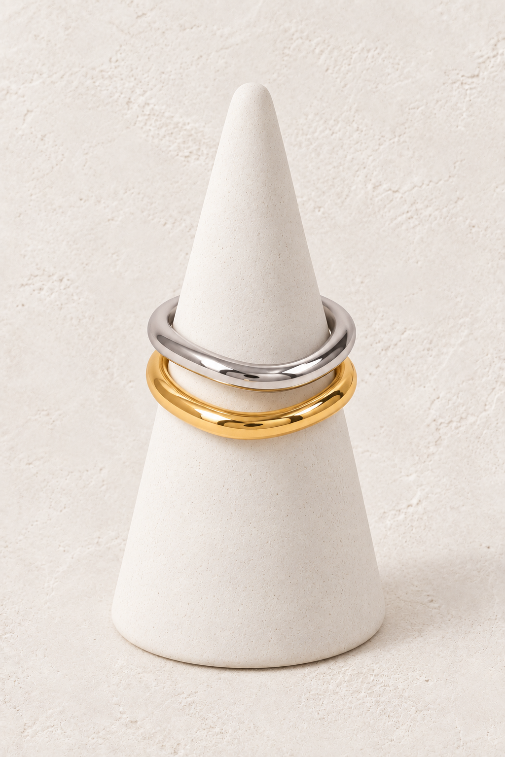
                  
                    Molten Oval Ring Set on a white display cone against a warm textured background
                  
                
