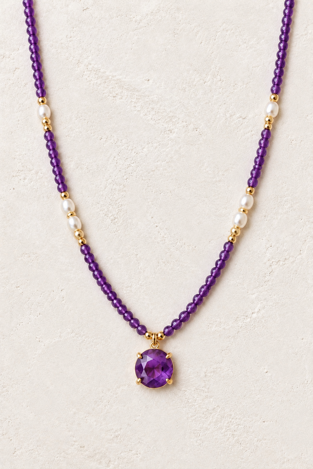 Novara Amethyst Pendant Necklace on the Boho & Mala cream stone hero background