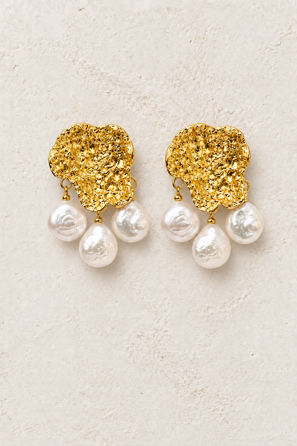 Pearl Bloom freshwater pearl gold statement earrings on warm textured background