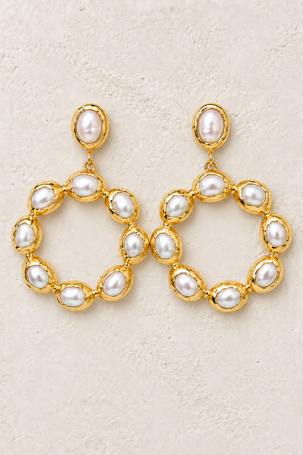 Pearl Soleil freshwater pearl statement earrings on a warm off-white textured background