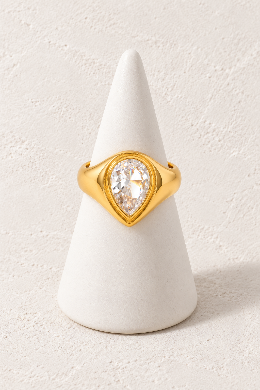 Radiance Signet Ring Size 7 on a white display cone against a warm textured background