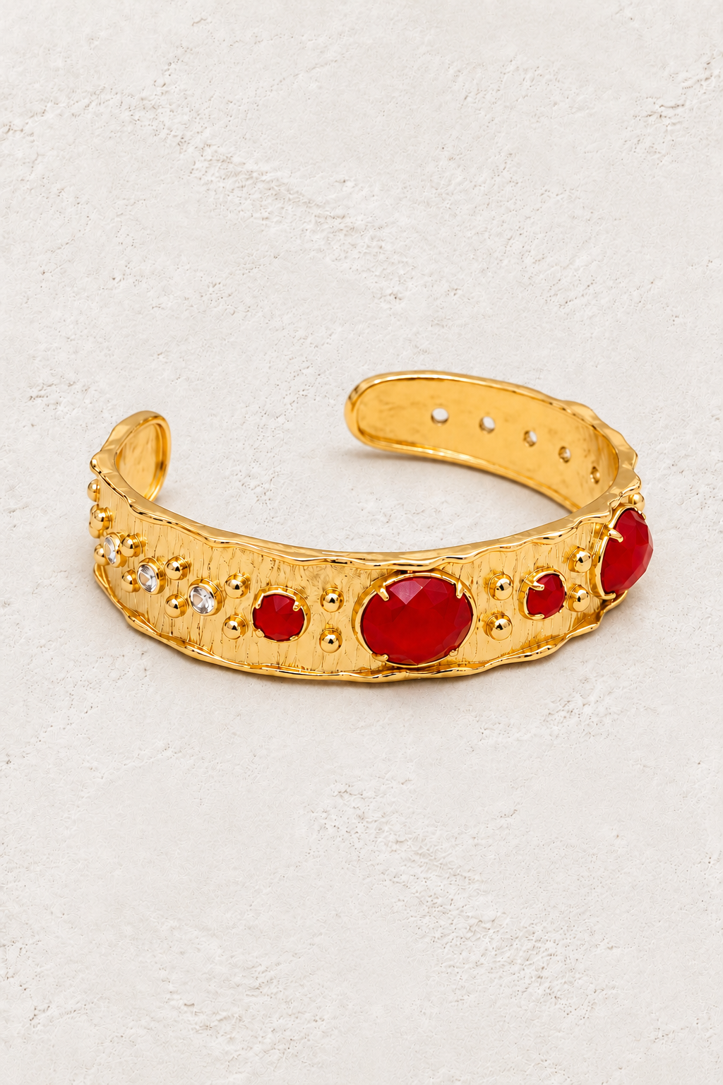 Red Jade Solara gold cuff bracelet on warm ivory plaster