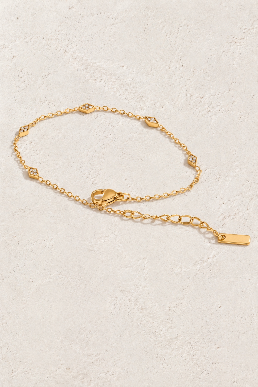 gold rhombus cubic zirconia bracelet on approved cream hero background