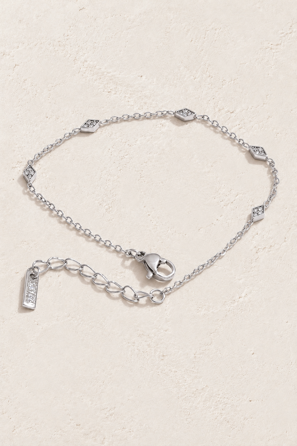 silver rhombus cubic zirconia bracelet on approved cream hero background