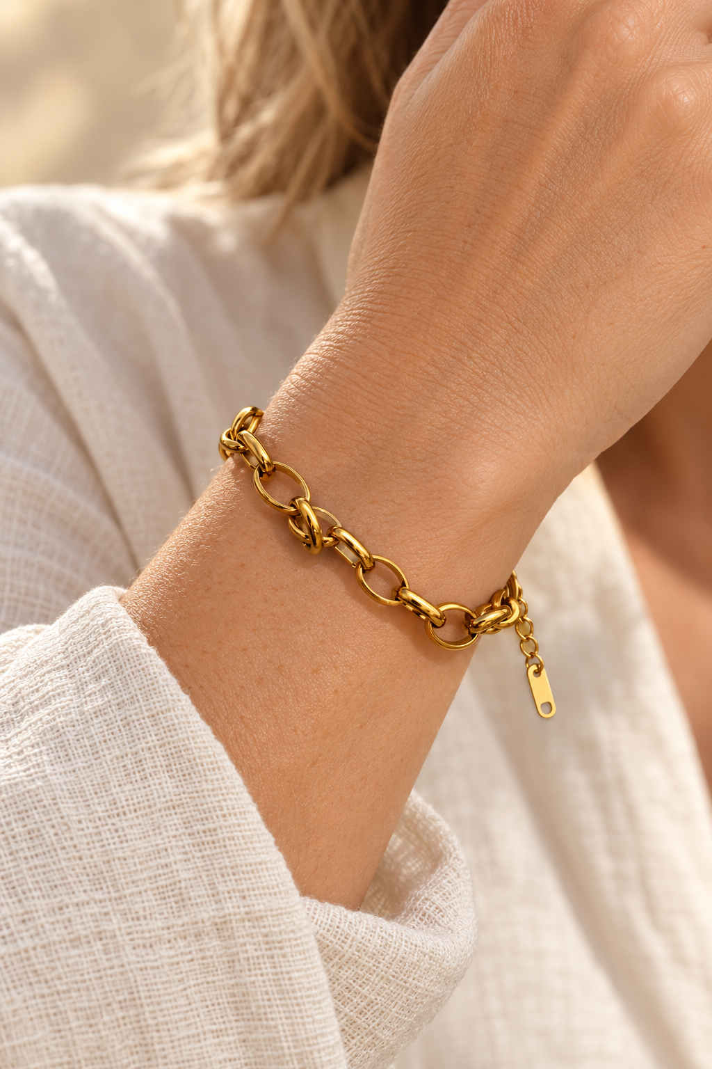
                  
                    Romina Gold Flat Oval Link Bracelet worn on a model's wrist
                  
                