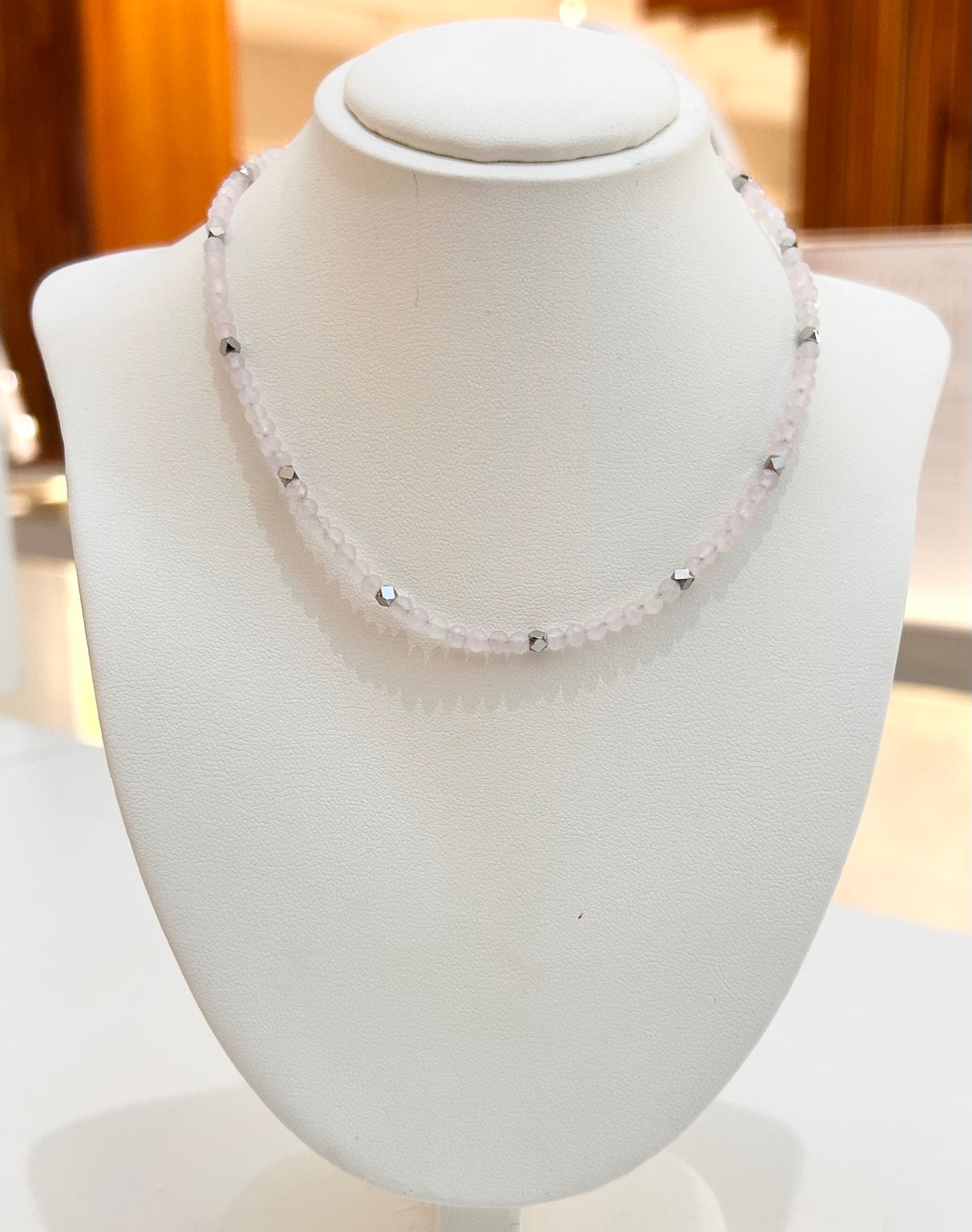 
                  
                    Rosalith Rose Quartz and silver-tone bead necklace displayed on a jewellery bust
                  
                