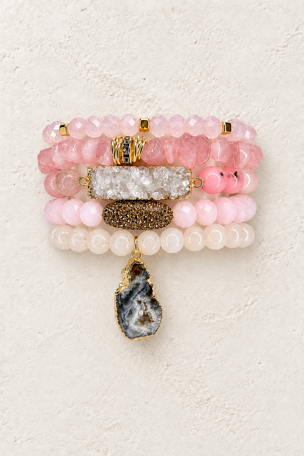 Rosé All Day five-piece pink stone elastic bracelet stack on warm textured background