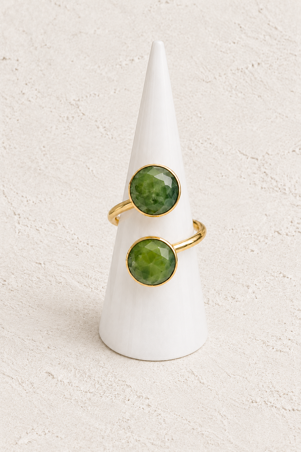 Sage Green Jade Ring on white cone against warm textured background