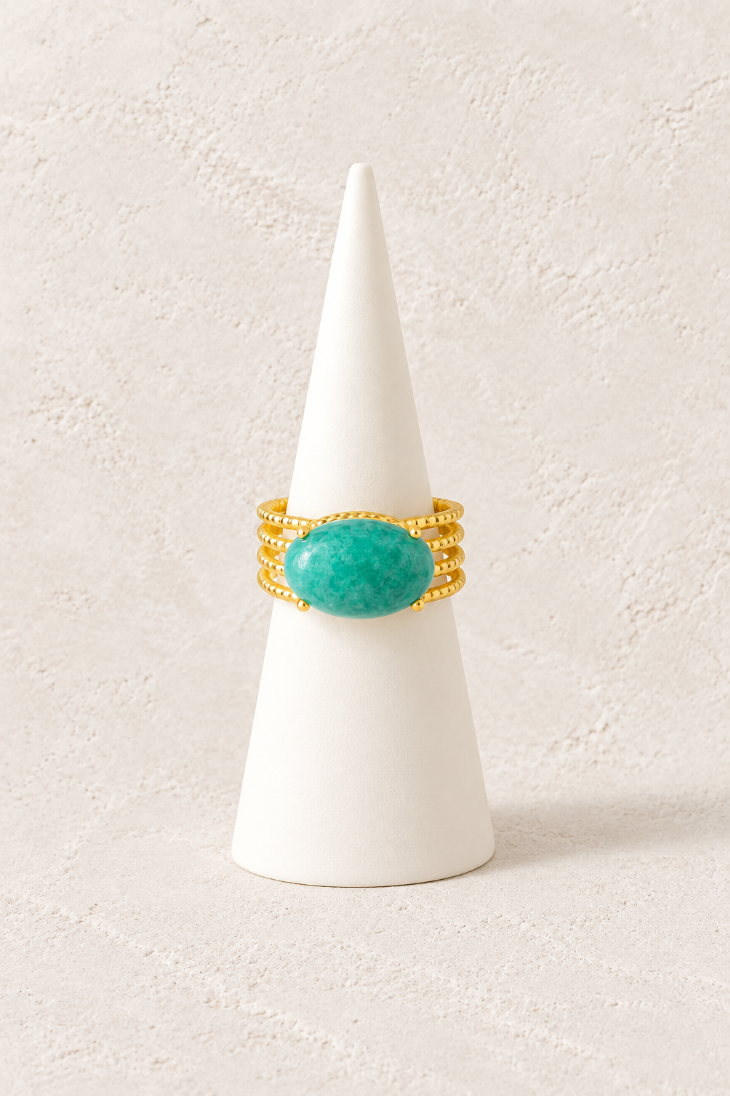 Sahara Amazonite Layered Ring on a white display cone against a warm textured background