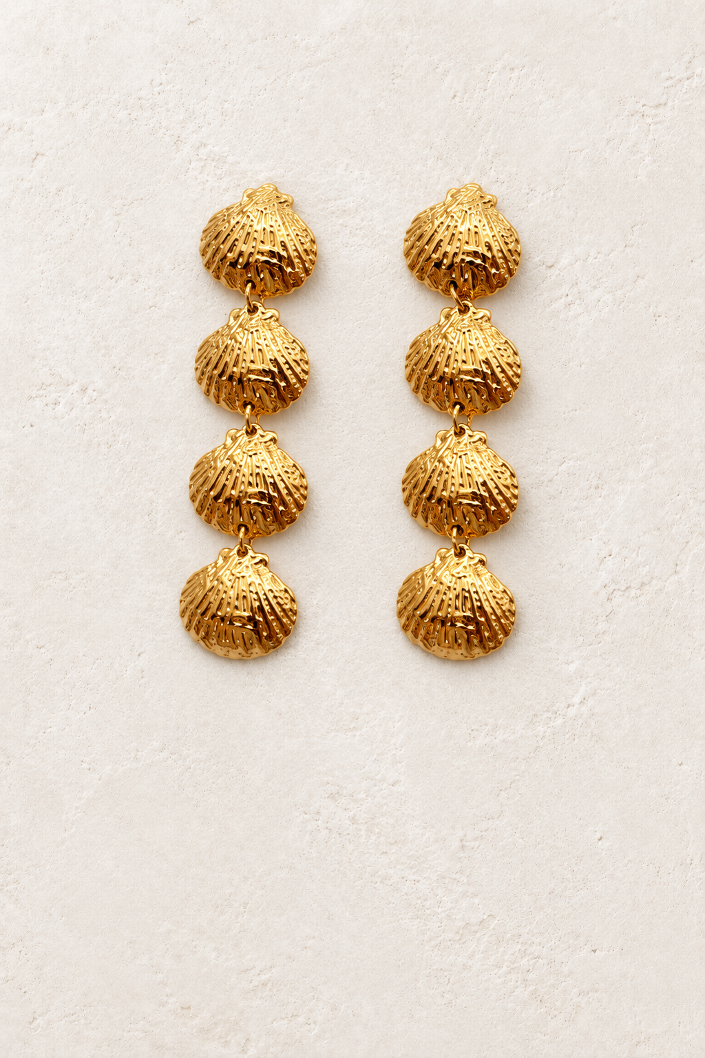 
                  
                    Seaside Gold Cascading Shell Earrings on cream plaster background
                  
                
