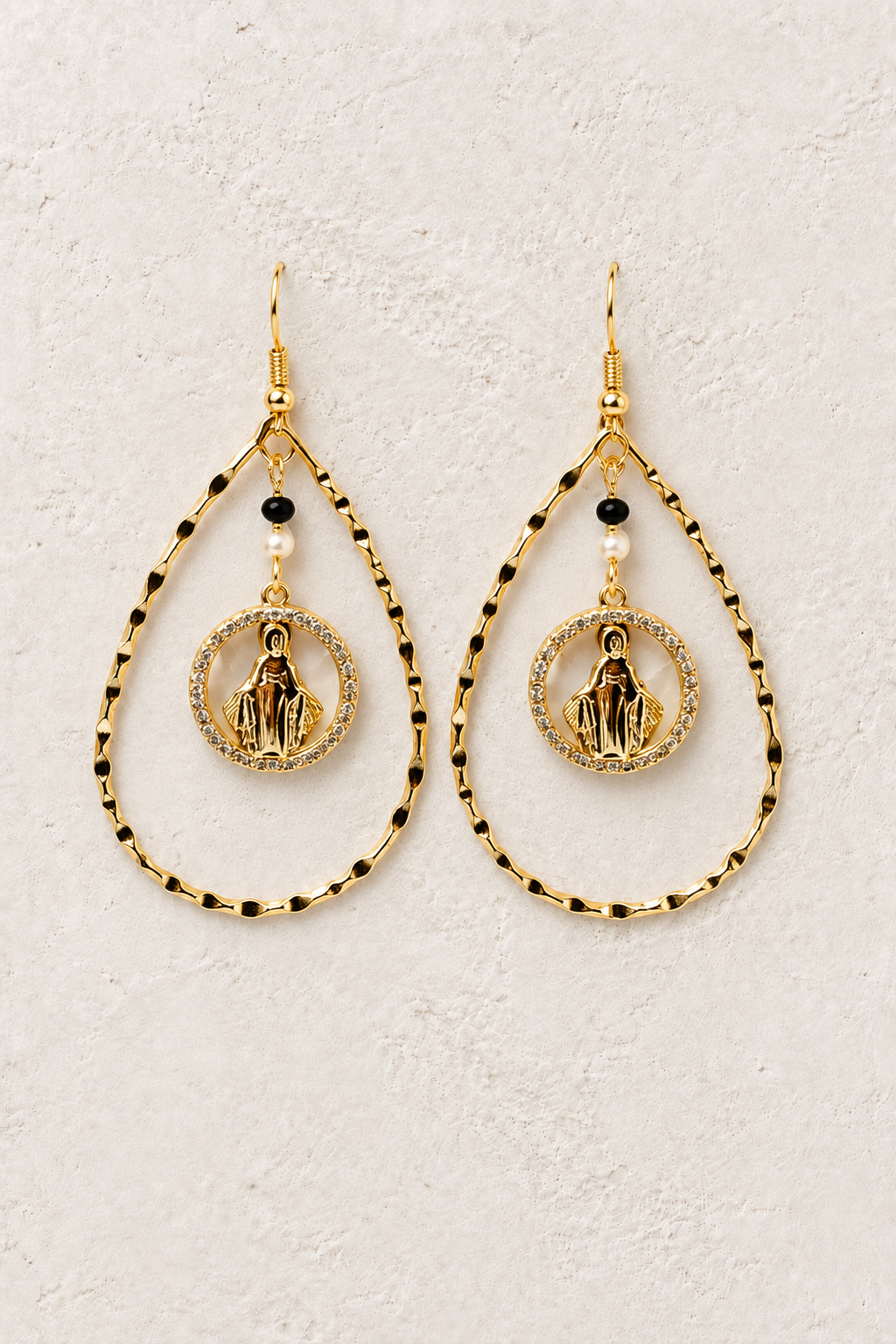 
                  
                    Seraphina gold medallion drop earrings on a warm textured background
                  
                