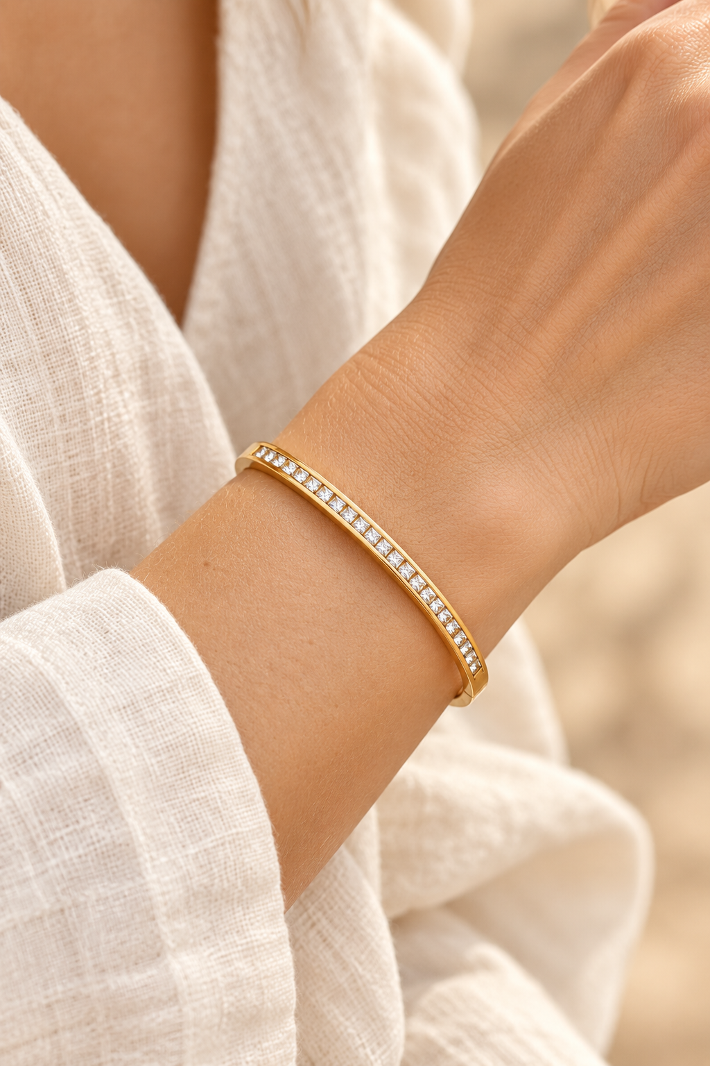 
                  
                    Serene Gold Clear Crystal Bangle worn on a model's wrist
                  
                