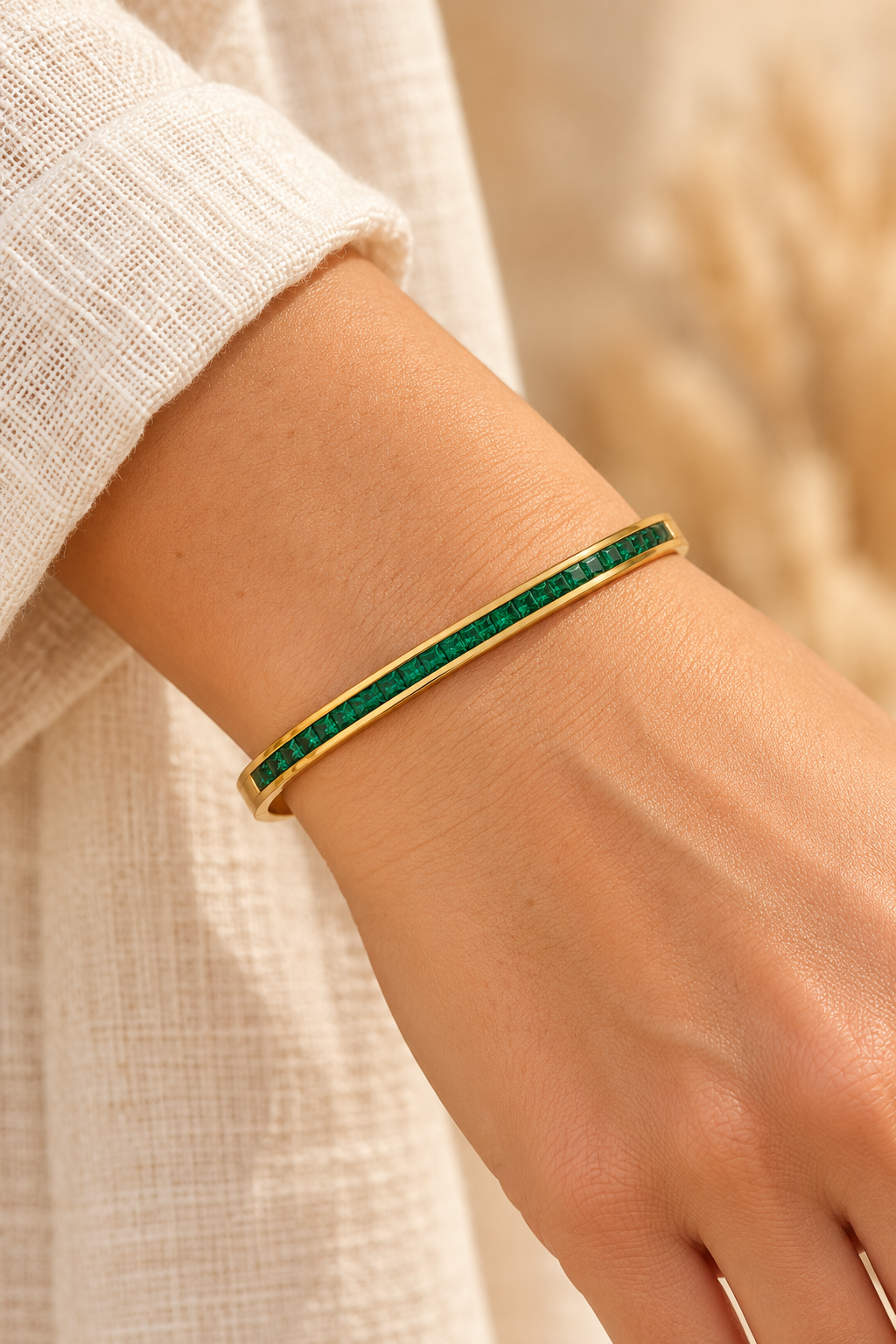 
                  
                    Serene Gold Green Crystal Bangle worn on a model's wrist
                  
                
