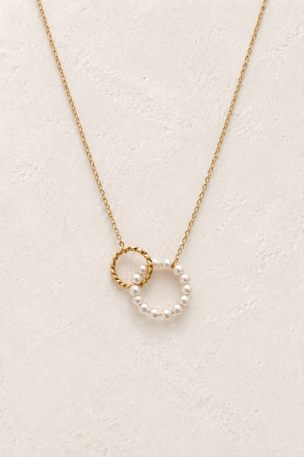 Serenelle pearl orbit waterproof gold necklace on a neutral background