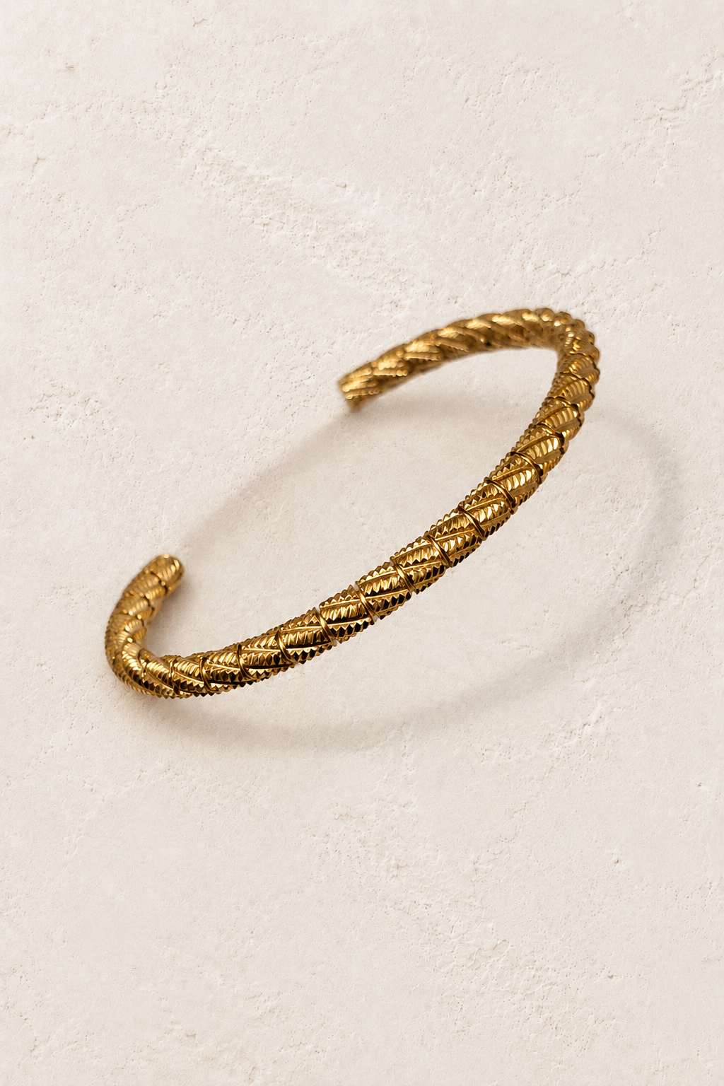 Sienna Gold Rope Bangle on cream beige textured background