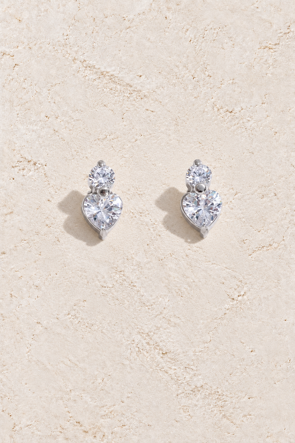 silver cubic zirconia heart stud earrings on cream plaster