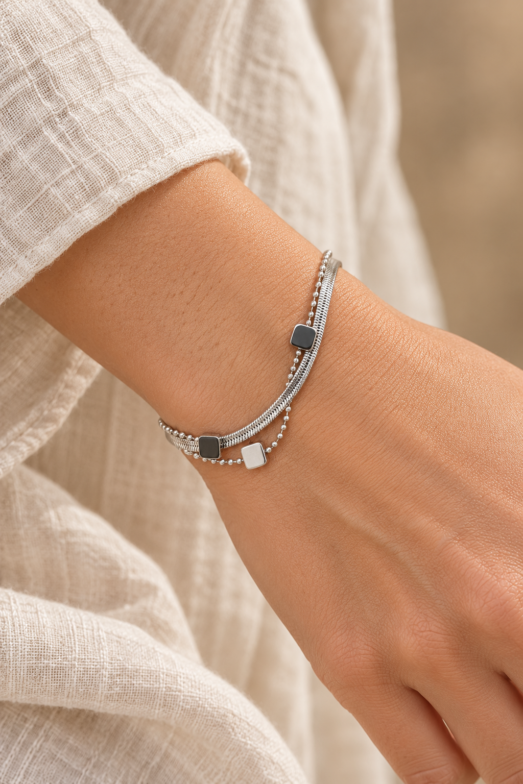 
                  
                    Silver Layered Square Charm Bracelet worn on a model's wrist
                  
                