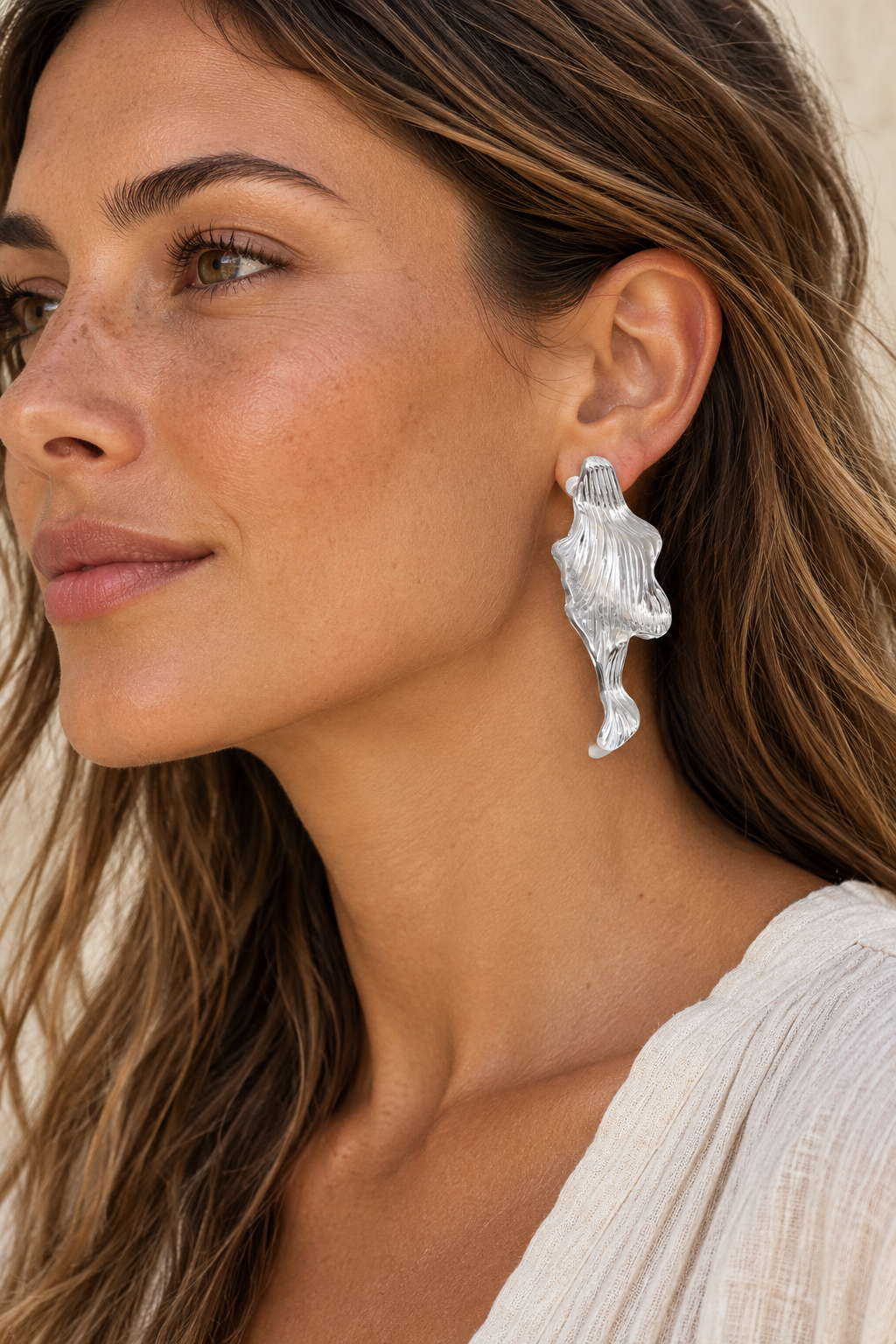 Silver 50mm sculptural ridged wave earrings worn on model