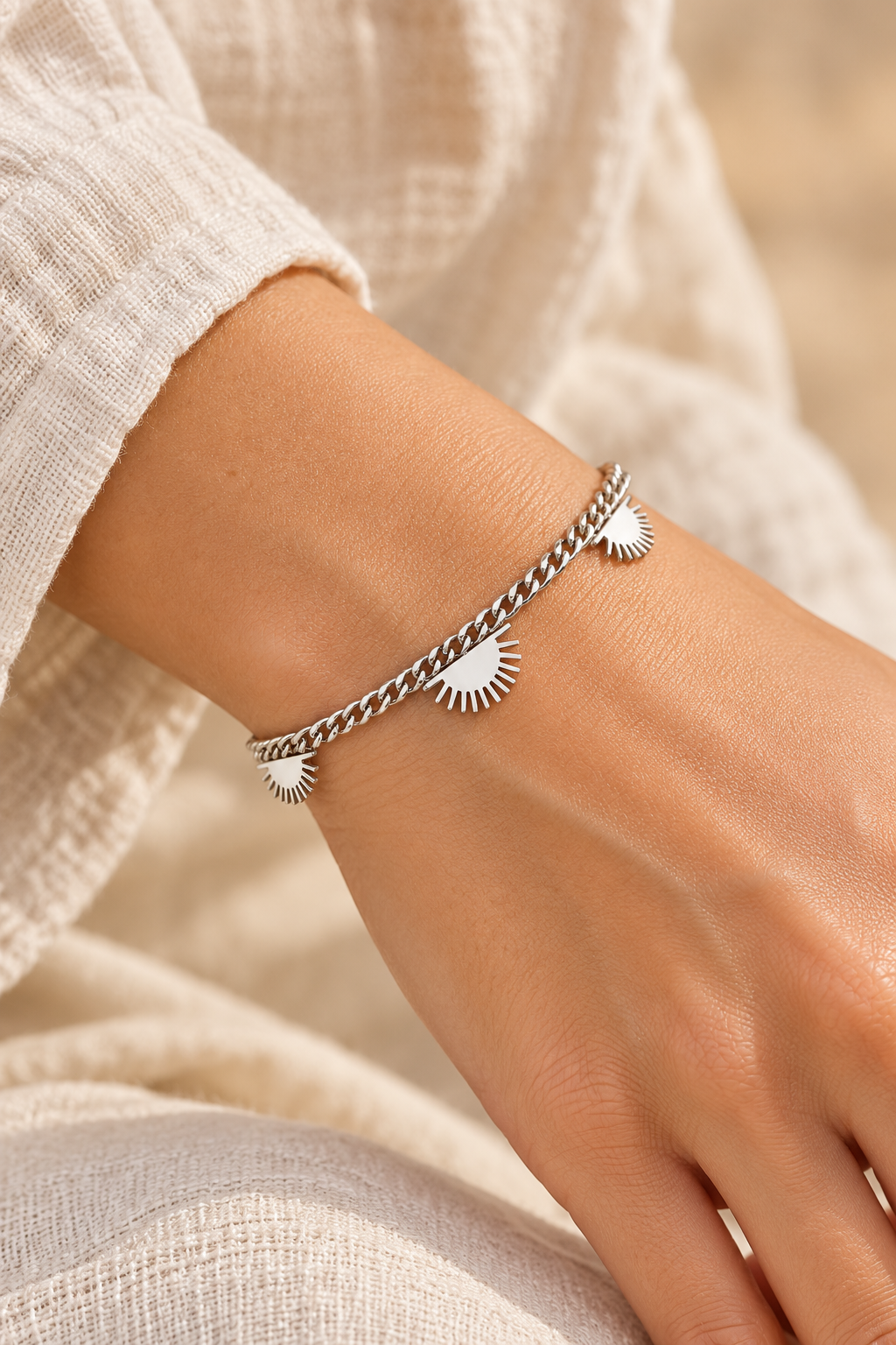 
                  
                    Silver Sunburst Charm Chain Bracelet worn on a model's wrist
                  
                