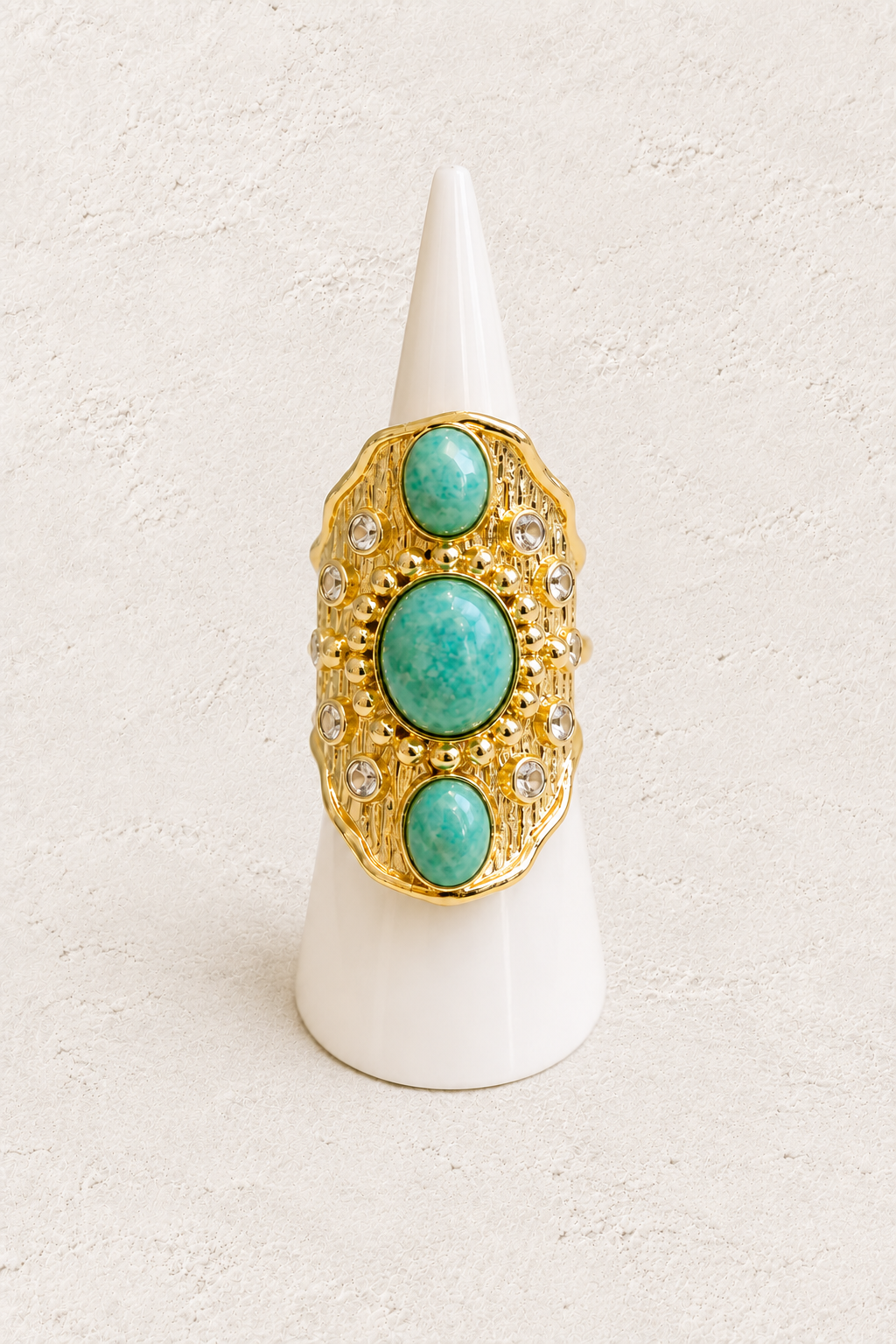 Solara Amazonite Ring on white cone against warm textured background