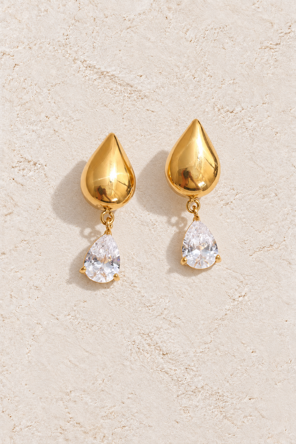Gold Polished Teardrop Crystal Drop Earrings on cream plaster