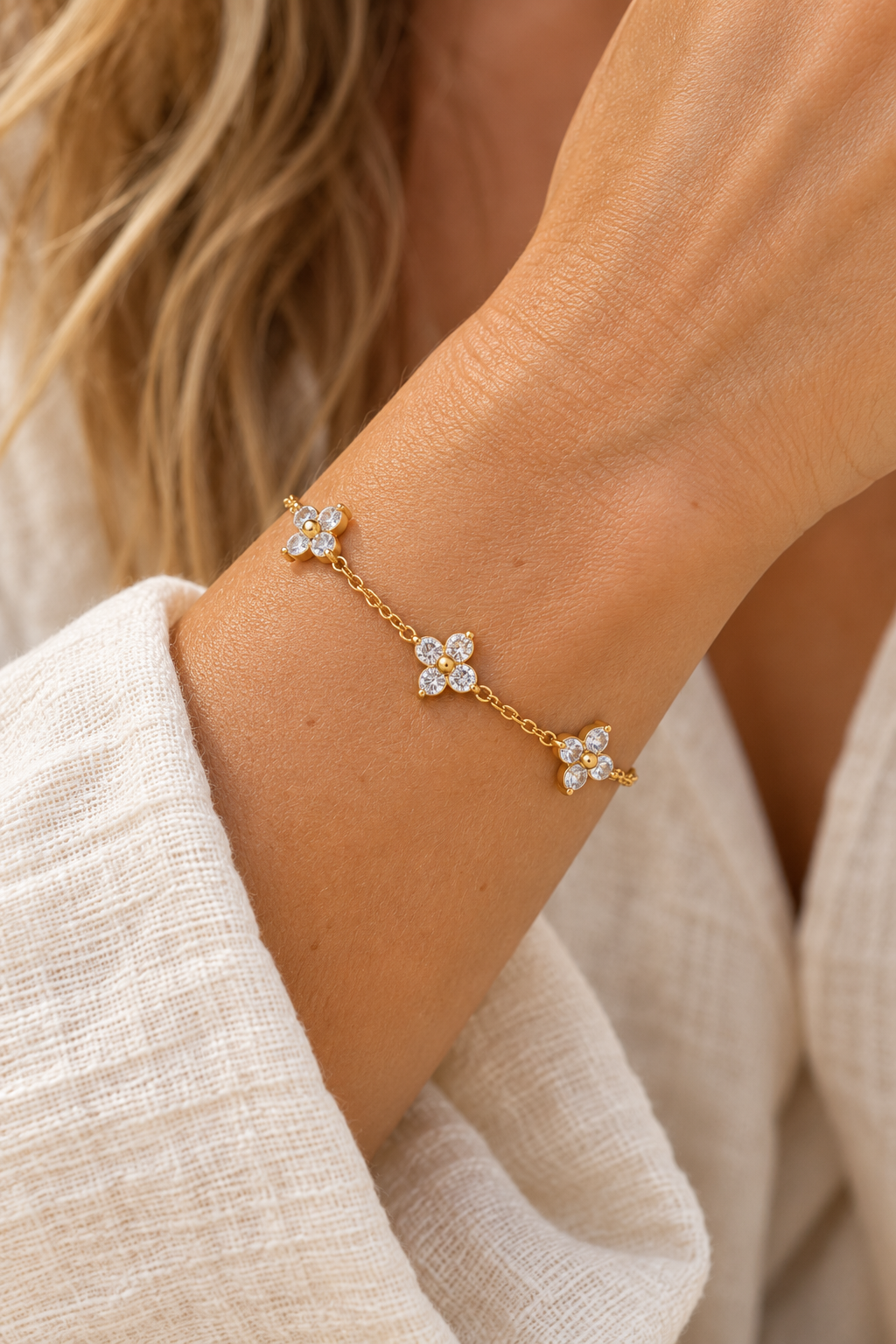 Gold triple crystal flower bracelet worn on wrist