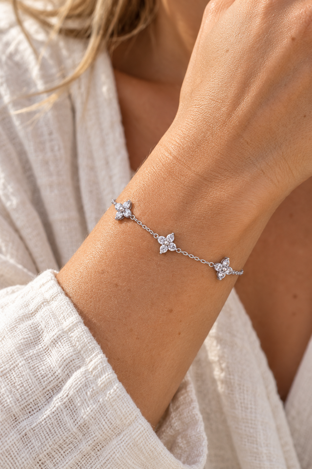 Silver triple crystal flower bracelet worn on wrist