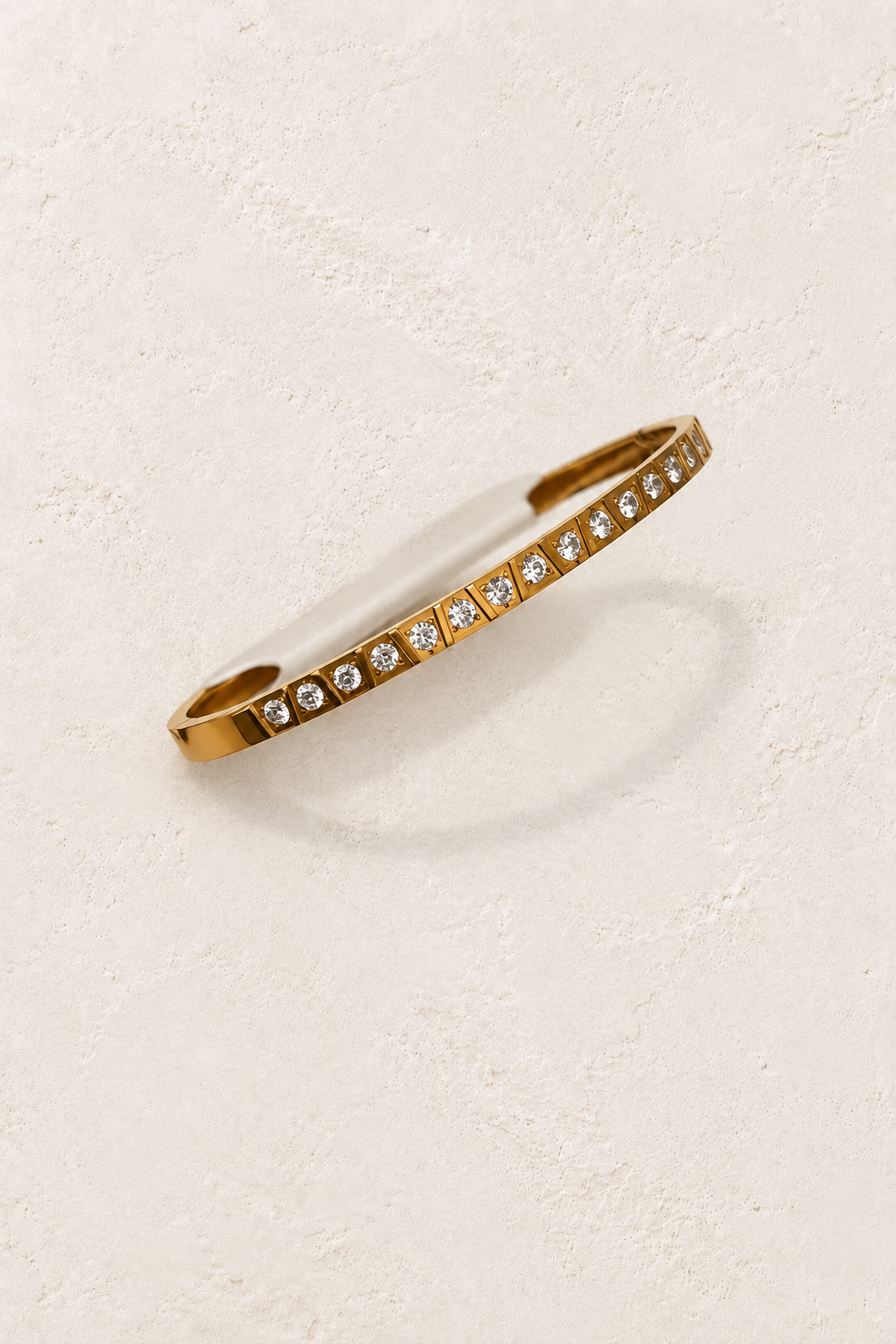 Vela Gold Square Set Crystal Bangle on cream beige textured background