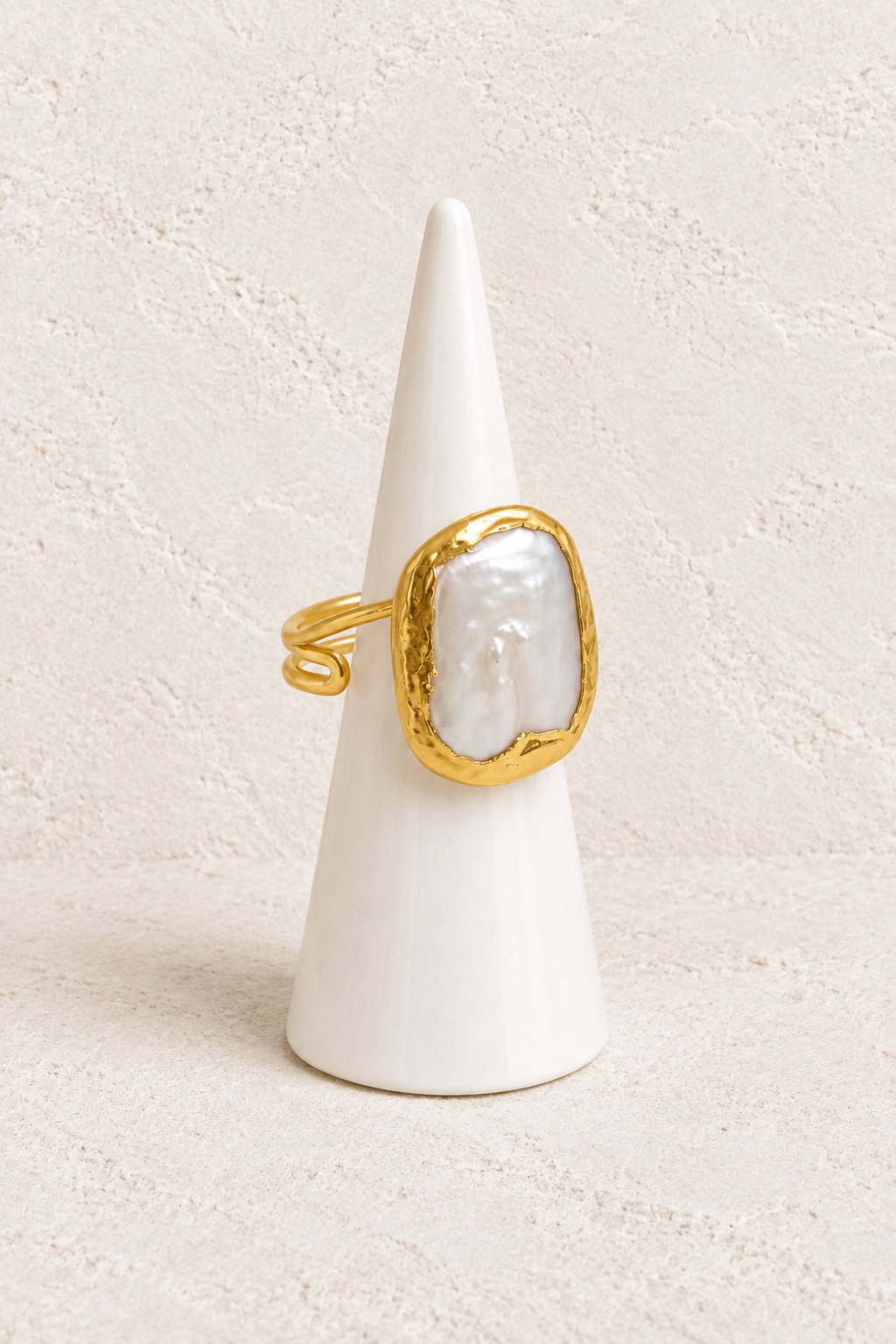 Vianne Baroque Pearl Statement Ring on a white display cone against a warm textured background